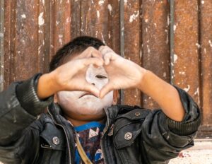 NIÑO HACIENDO SEÑA DE CORAZÓN
